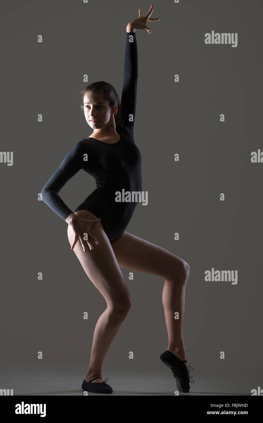 Porträt von schönen jungen Tänzerin Frau im schwarzen Trikot, Sport, tanzen, Ganzkörperansicht, Studio, dunkler Hintergrund Stockfoto