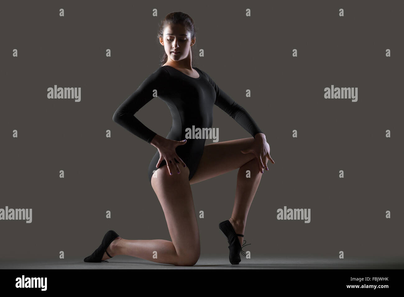 Porträt der schönen anmutigen jungen Tänzerin Frau im schwarzen Trikot, Sport, tanzen, Ganzkörperansicht, Studio, dunkler Hintergrund Stockfoto