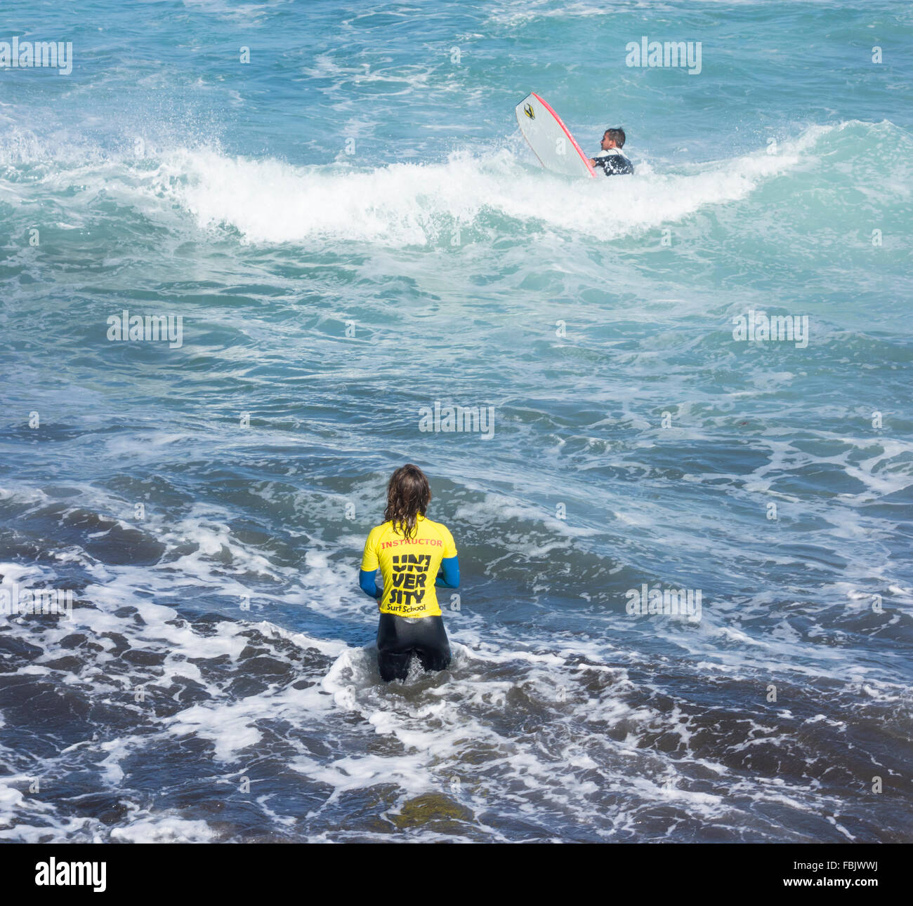 Weibliche Surflehrer stehen im Meer, die Lektion zu geben Stockfoto