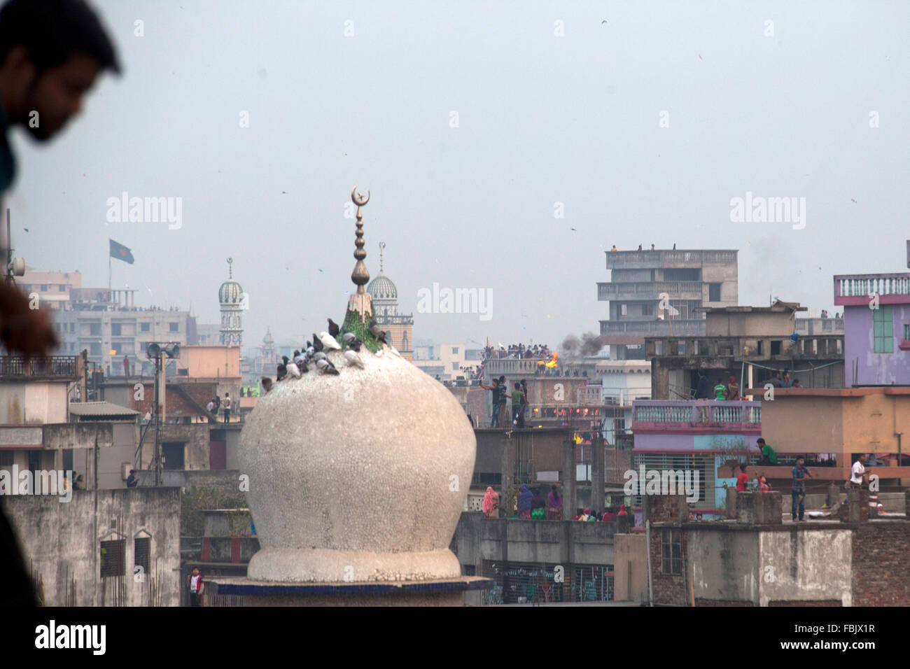 DHAKA, Bangladesch 14. Januar 2016: Menschen von alten Dhaka spielen Feuer Spliting mit Kerosin Öl auf dem Dach ihres Gebäudes anlässlich des Shakrain Festivals in Dhaka am 14. Januar 2016. Das Shakrain Festival hat in Shakhari Bazar Gegend in der Altstadt von Dhaka stattgefunden. Shakrain Festival auch bekannt als Kite Festival wird am Ende des Monats Poush Bangla in Dhaka, Bangladesch gefeiert. Shakrain Festival in einem alten, berühmten und wichtigen jährlichen Festival von Bangladesch. Es ist das Symbol der Einheit und Freundschaft in Bangladesch. Shakrain Festival ist wichtig, besonders für f Stockfoto