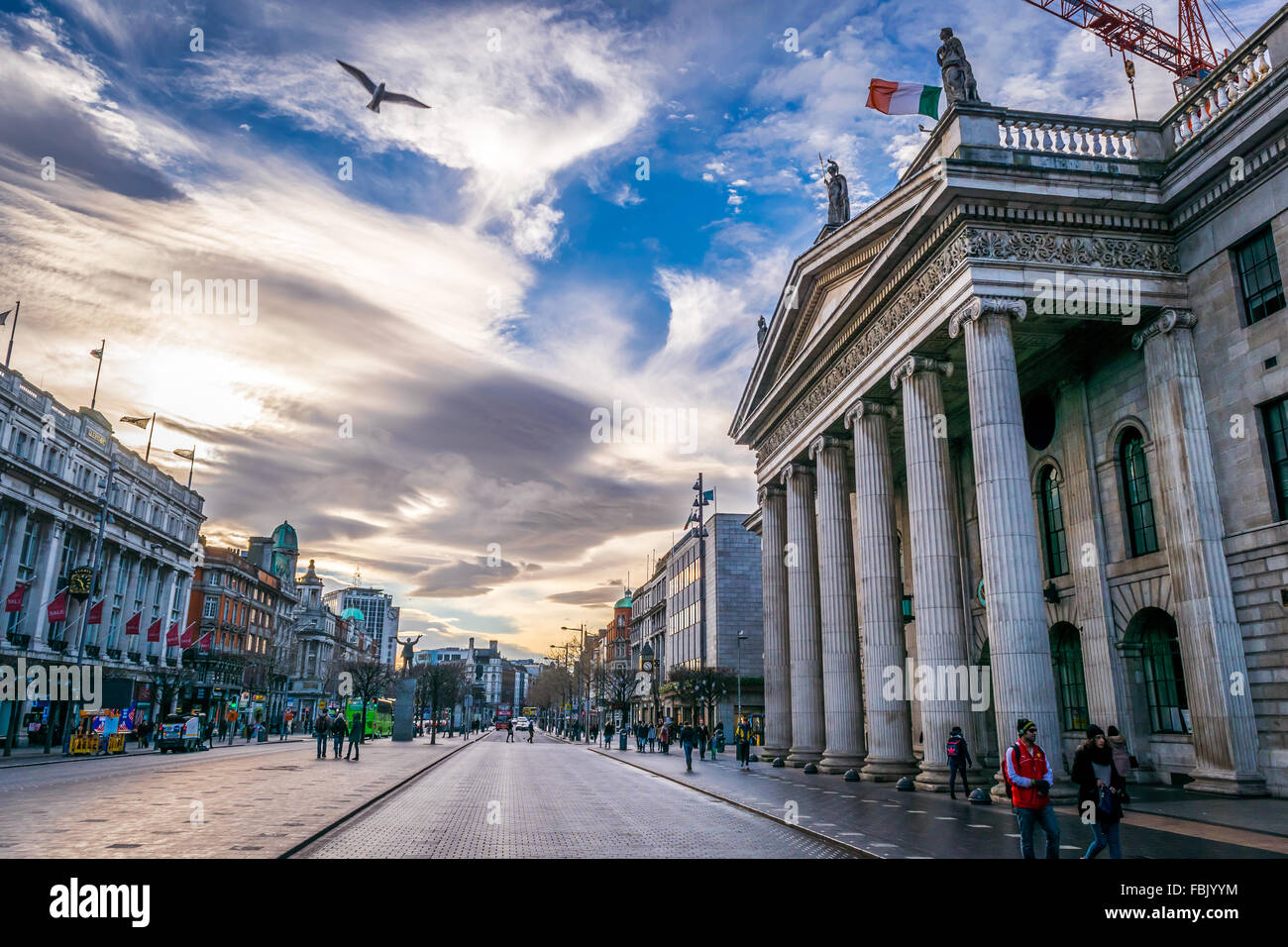 Ein Vogel segelt über die historischen GPO aufbauend auf Dublins O' Connell Street, während die irische Nationalflagge an der Spitze fliegt. Stockfoto