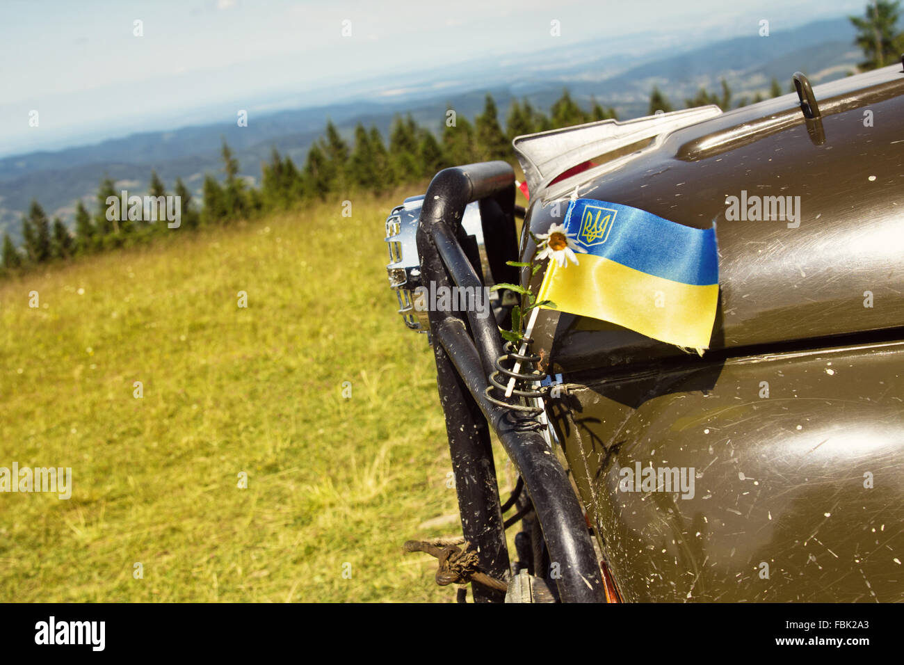 Ukrainische Flagge auf einem Auto über blauen Himmelshintergrund Stockfoto