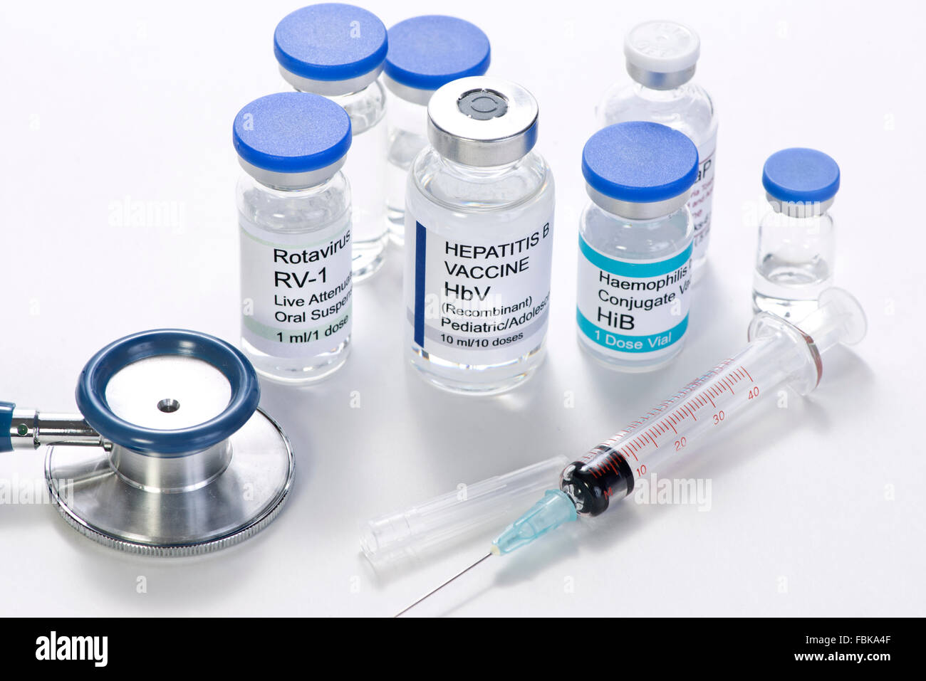 Kindheit Impfstoff Fläschchen mit Spritze und Stethoskop.  Alle Etiketten sind frei erfunden und jede Ähnlichkeit mit tatsächlichen Produkten ist coinc Stockfoto