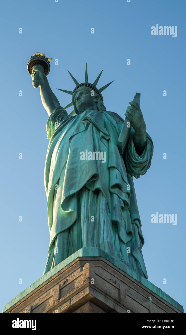 Blick auf die ganze Statue of Liberty von unten mit einem wolkenlosen blauen Himmel. Stockfoto