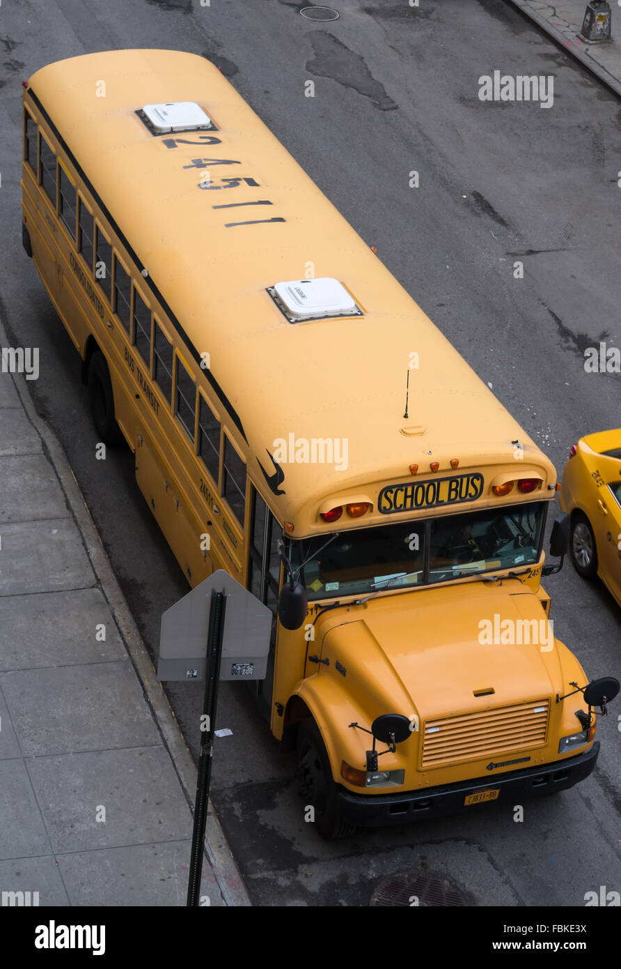 Blick nach unten auf einen traditionellen gelben amerikanischen Schulbus in der Straße geparkt. Stockfoto