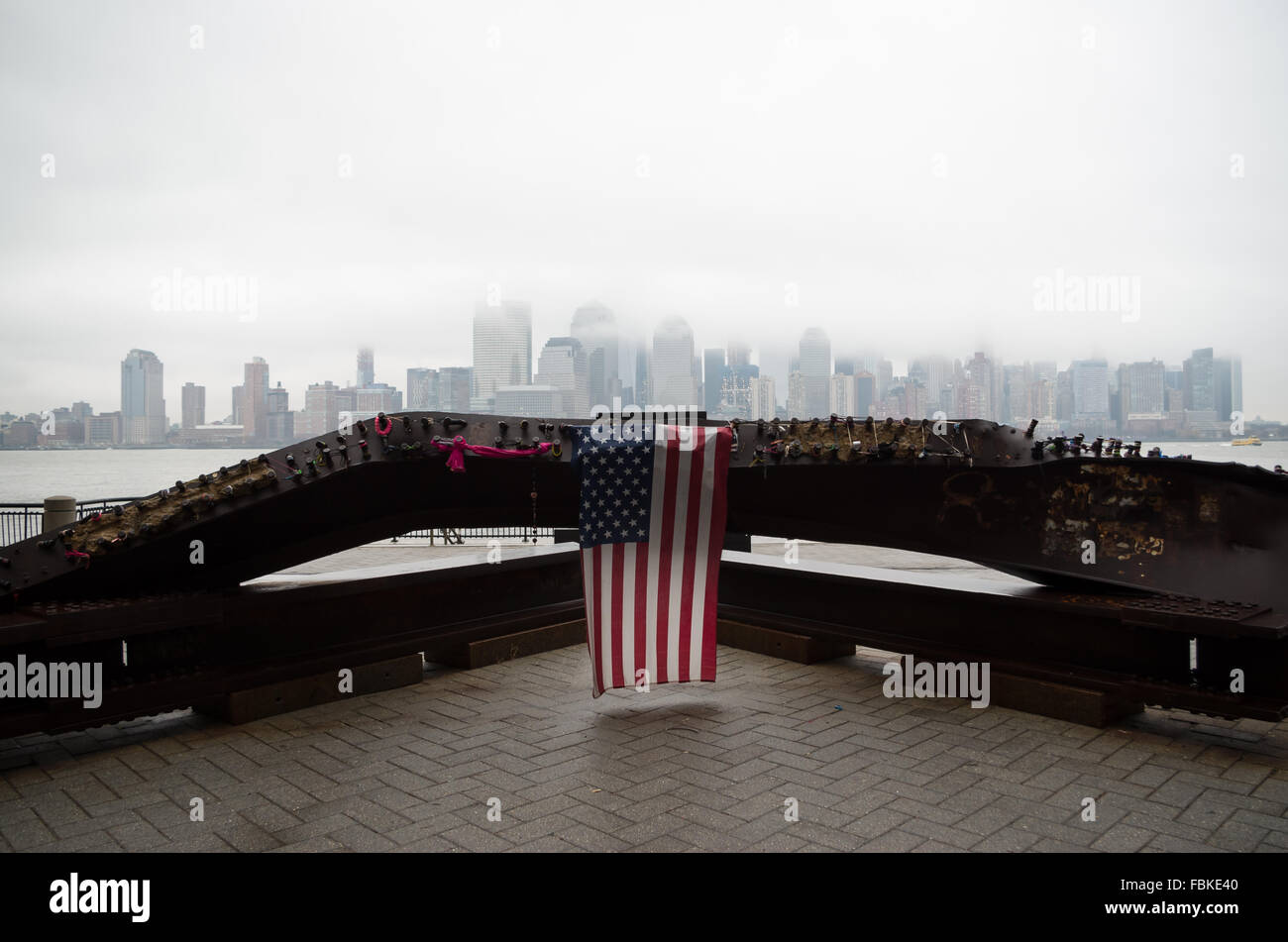 Denkmal für 9/11 Terroranschlag auf Jersey City Waterfront mit dem NYC Skyline im Hintergrund von niedrigen Wolken bedeckt. Stockfoto