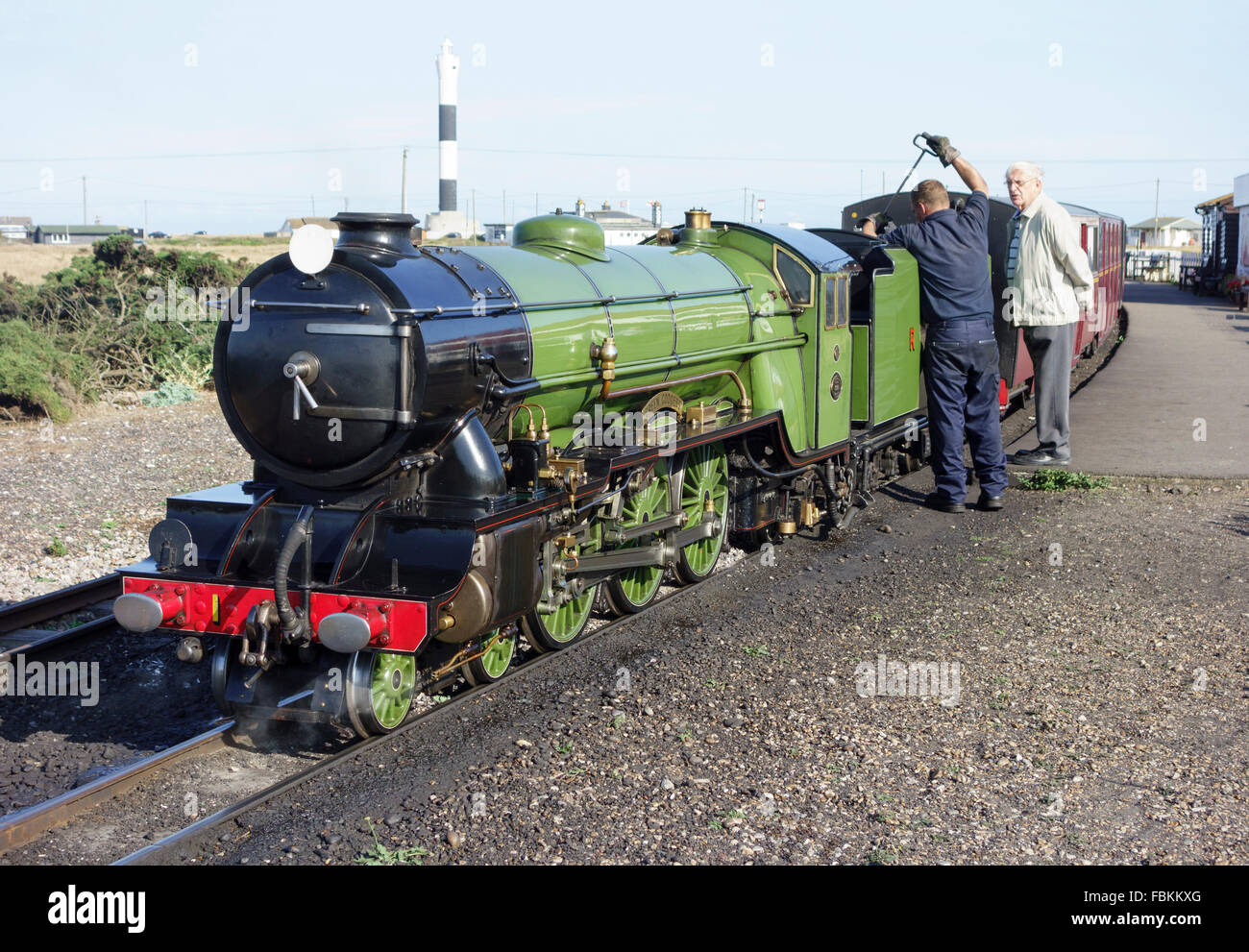 England, Kent, Dungeness. Ein Ingenieur prüft die Wasserstände in der Miniatur-Dampflokomotive, "Grüne Göttin" Stockfoto