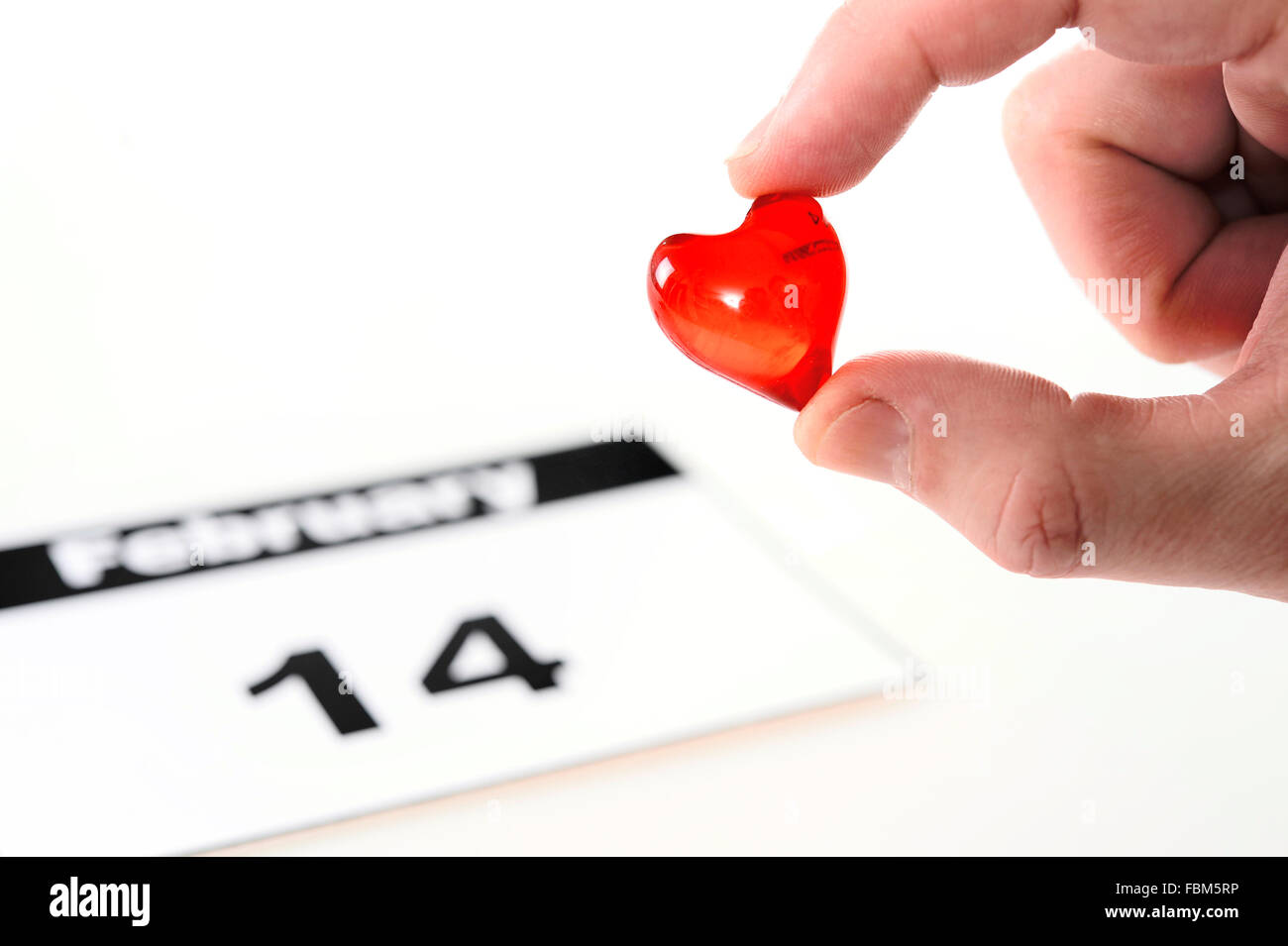 Valentinstag-Kalenderseite und Mann mit roten Herzchen Stockfoto
