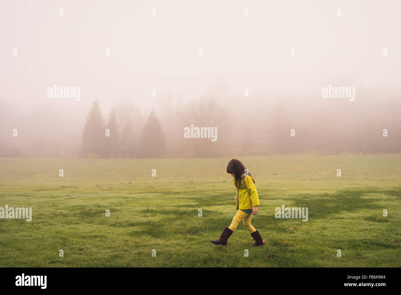 Seitenansicht eines Mädchens zu Fuß im Park an einem nebeligen Tag Stockfoto