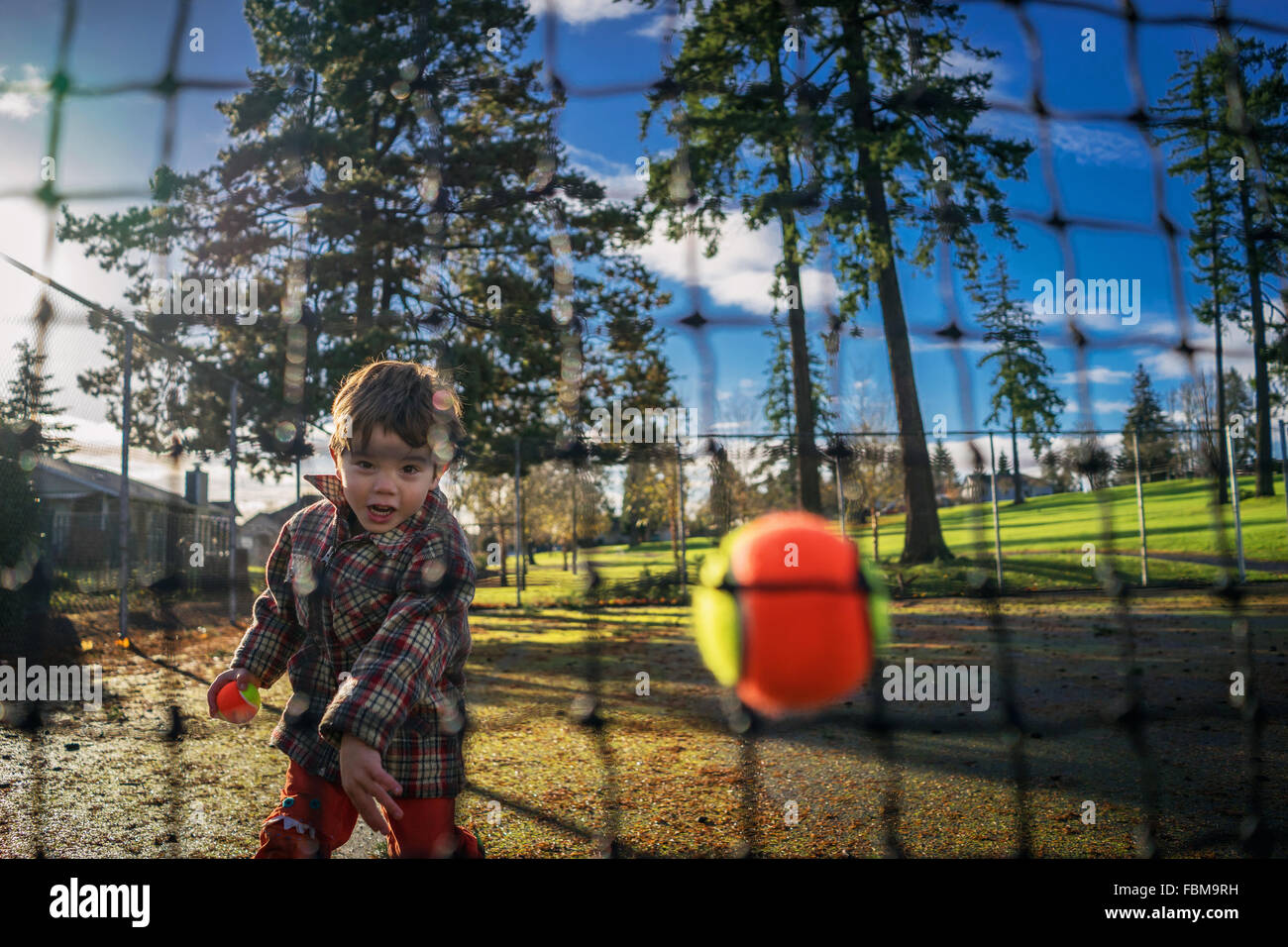 Kleiner Junge ein Netz Tennisball bewerfen Stockfoto