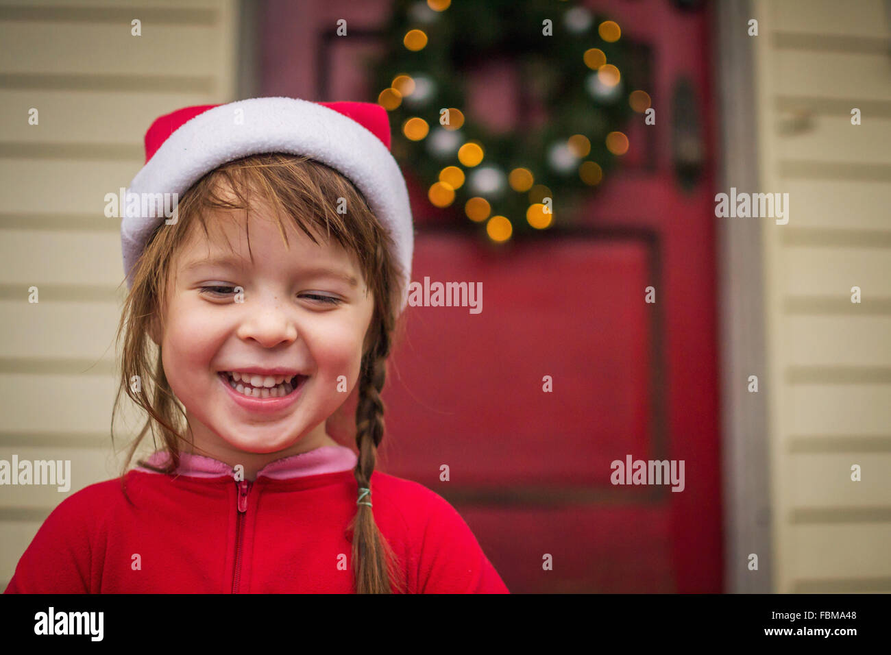 Glückliches Mädchen im Weihnachten Hut stehen vor Haus Stockfoto