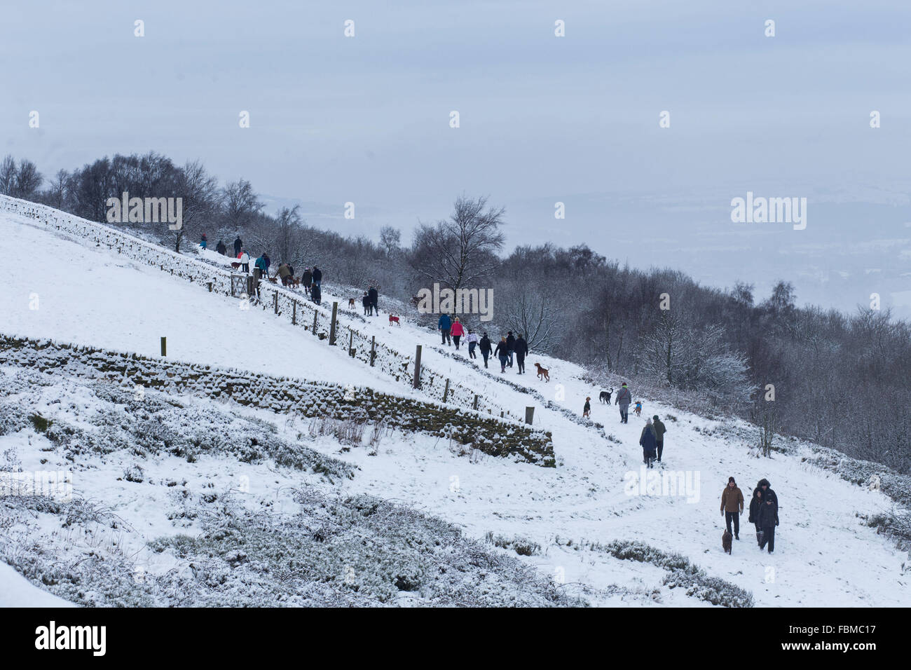 Mitglieder der Öffentlichkeit genießen Sie die verschneite Bedingungen in Otley Chevin in Otley, West Yorkshire. Stockfoto