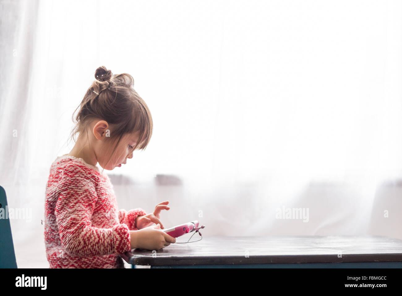 Mädchen am Tisch spielen mit digital-Tablette Stockfoto