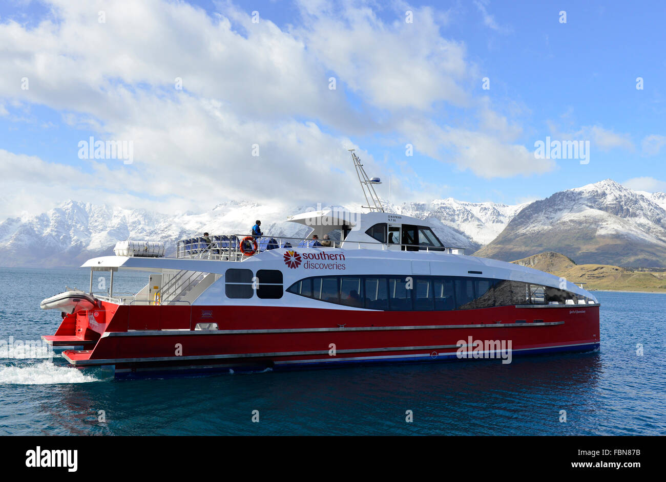 Südliche Entdeckungsfähre auf einer Bootstour mit dem Lake Wakatipu Die umliegenden Berge bieten eine dramatische Kulisse in Queenstown, Südinsel, Neuseeland Stockfoto