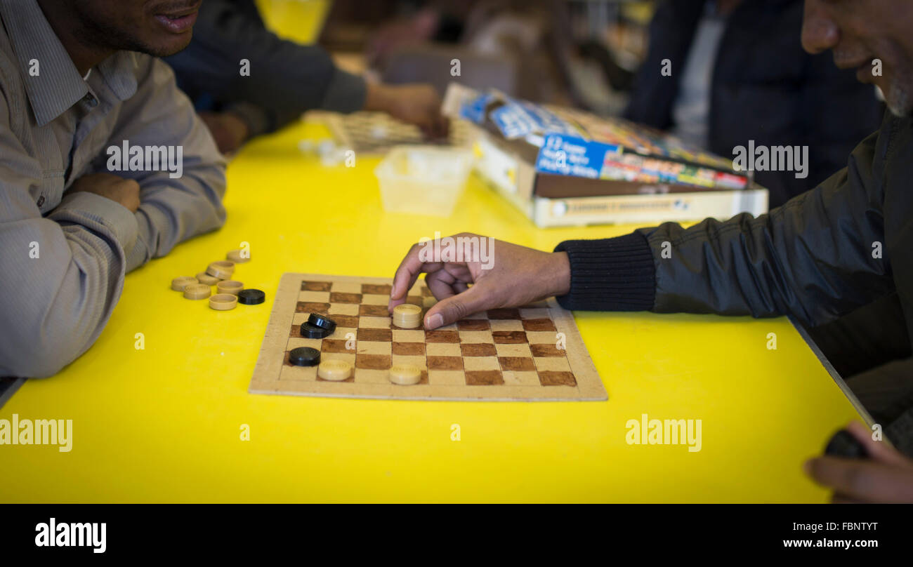 Zwei nicht identifizierbare Männer spielen Sie Zugluft (US - Dame) auf ein Gemeindezentrum Stockfoto