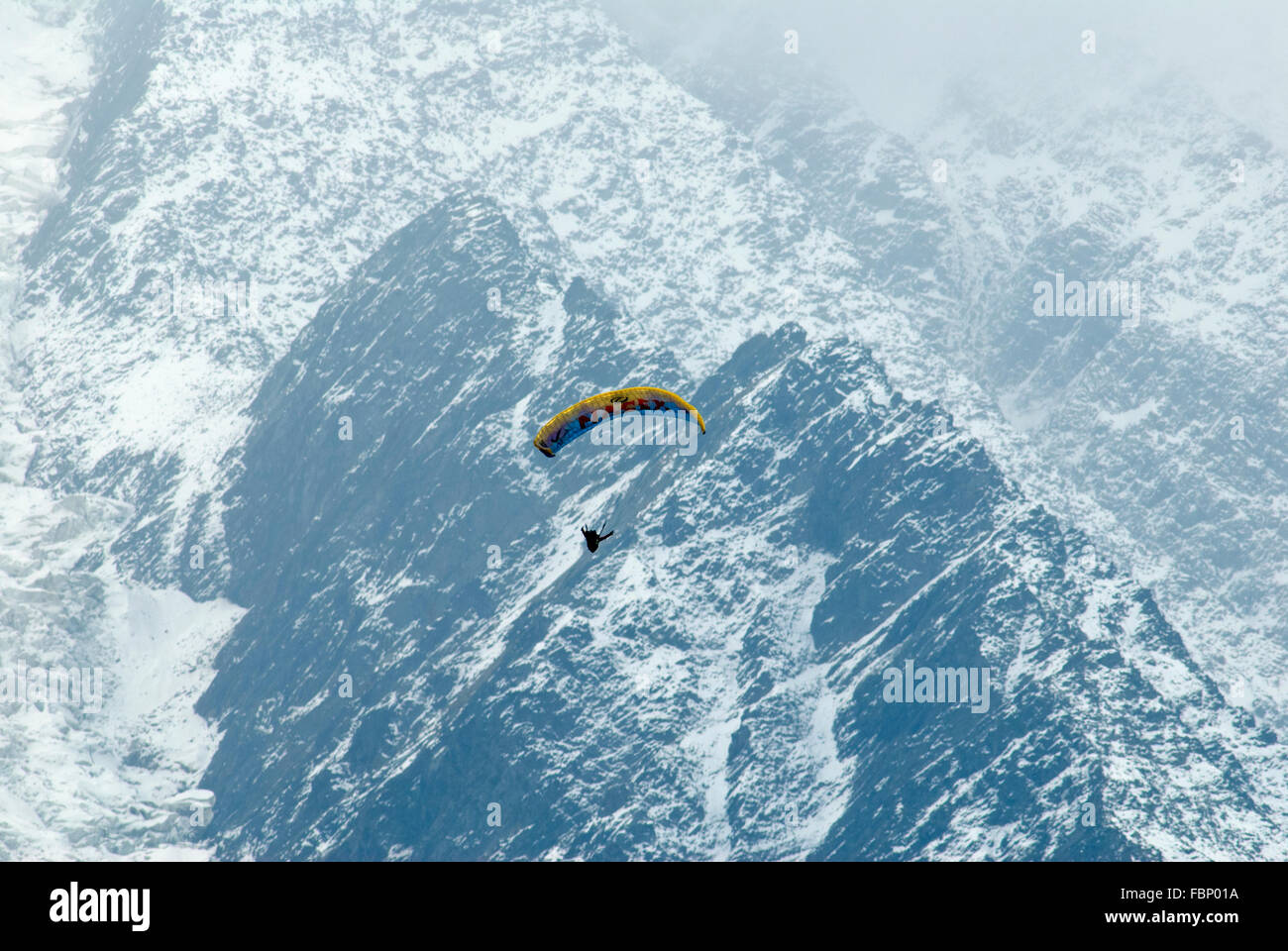 Gleitschirmflieger schweben hoch über dem Tal von Chamonix mit Schnee bestäubt Flanken des Mt-Blanc-Massiv hinter Stockfoto
