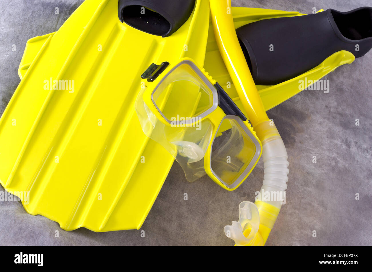 gelbe Schnorchel Maske und Flossen Schnorcheln Ausrüstung vor grauem Hintergrund isoliert Stockfoto