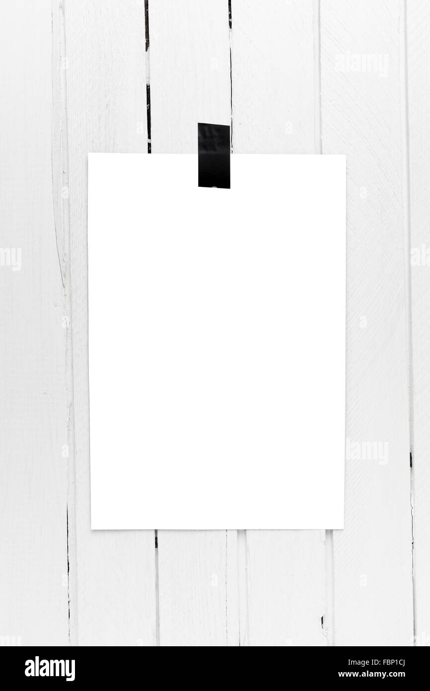 Leere weiße Plakat auf einem Band auf weißen Holzplatte Wand hängen. Stockfoto