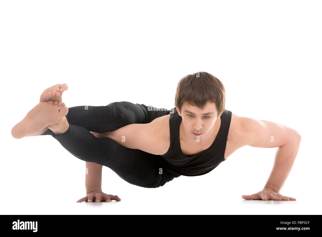 Sportliche junge Mann tut Yoga oder Pilates Arm balancieren Übungen, Asana Astavakrasana, asymmetrische Arm Gleichgewicht, acht-Winkel darstellen Stockfoto