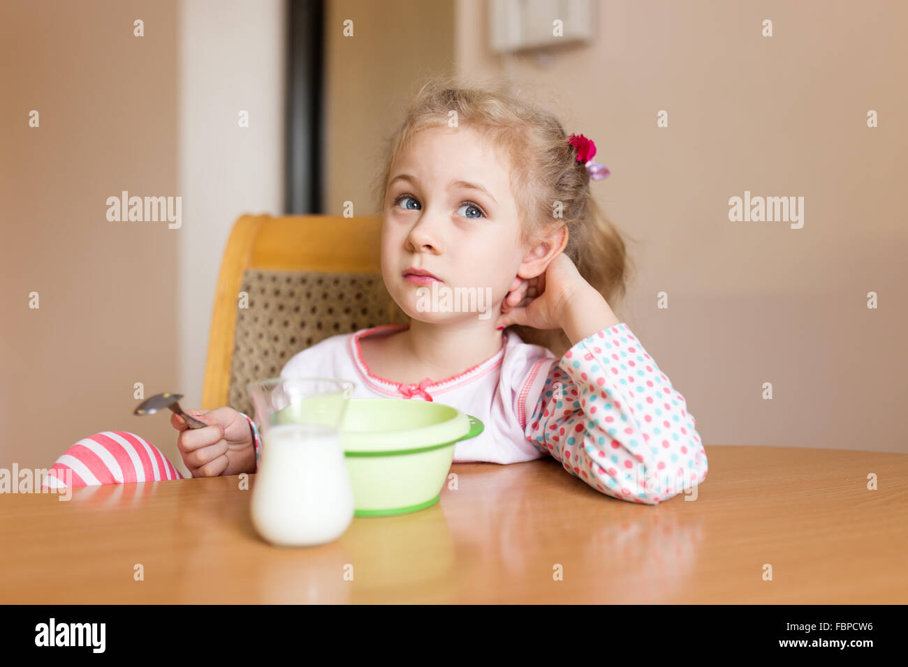 Kleines Mädchen zu Hause frühstücken. Milch-Schnurrbart Stockfoto