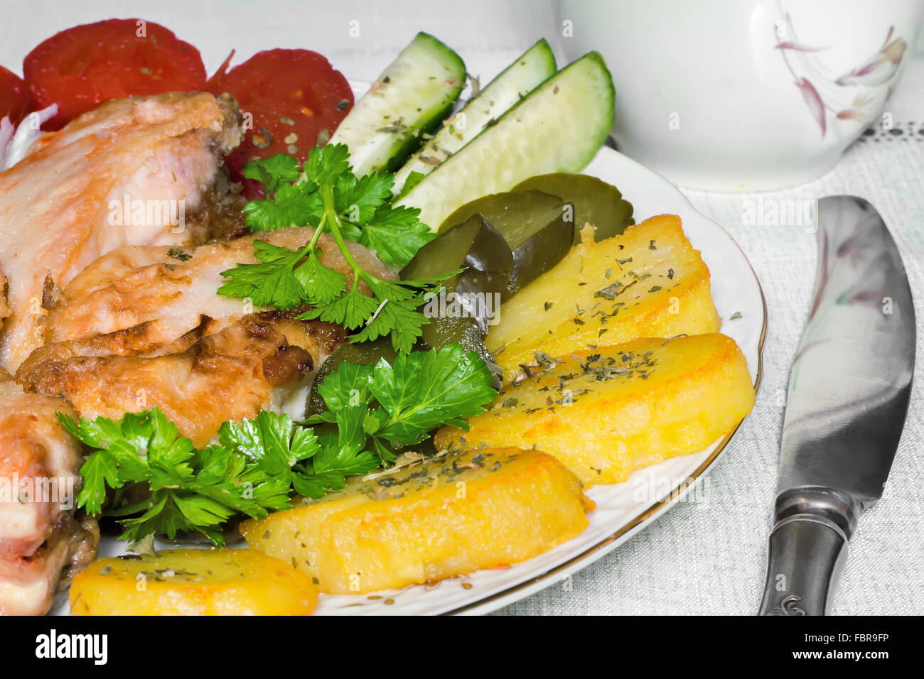 Auf dem Tisch ist eine Platte mit Stücken von lecker gebratenen Fisch und verschiedene Gemüse. Geschenke großen Plan. Stockfoto
