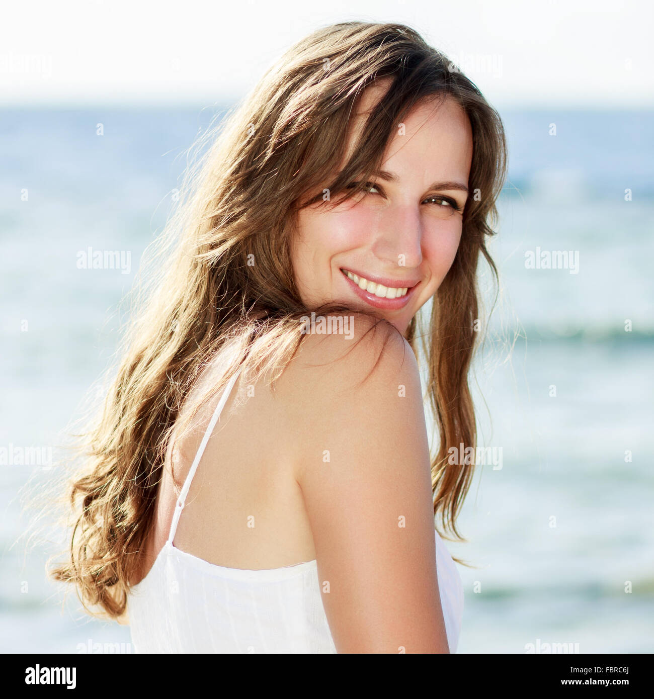 Glückliche Mädchen am Meer. Ziemlich lächelte Mädchen mit gesunden Zähnen Spaß in den Sommerferien Stockfoto