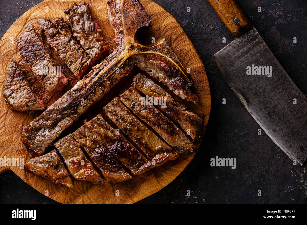 T-Bone Steak auf dem Board auf dunklem Hintergrund geschnitten Stockfoto