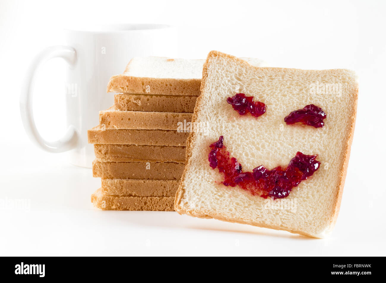 Ein Lächeln beim Frühstück, Erdbeermarmelade, verteilt auf eine Scheibe Brot gemacht. Stockfoto