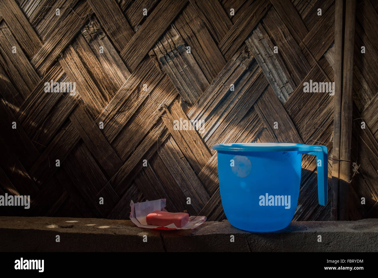 Stillleben: blauer Krug, Seife und Sunbeam Hütte Wand Rattan. Einfache und rustikale Umgebung. MAJULI Island, Indien. Stockfoto