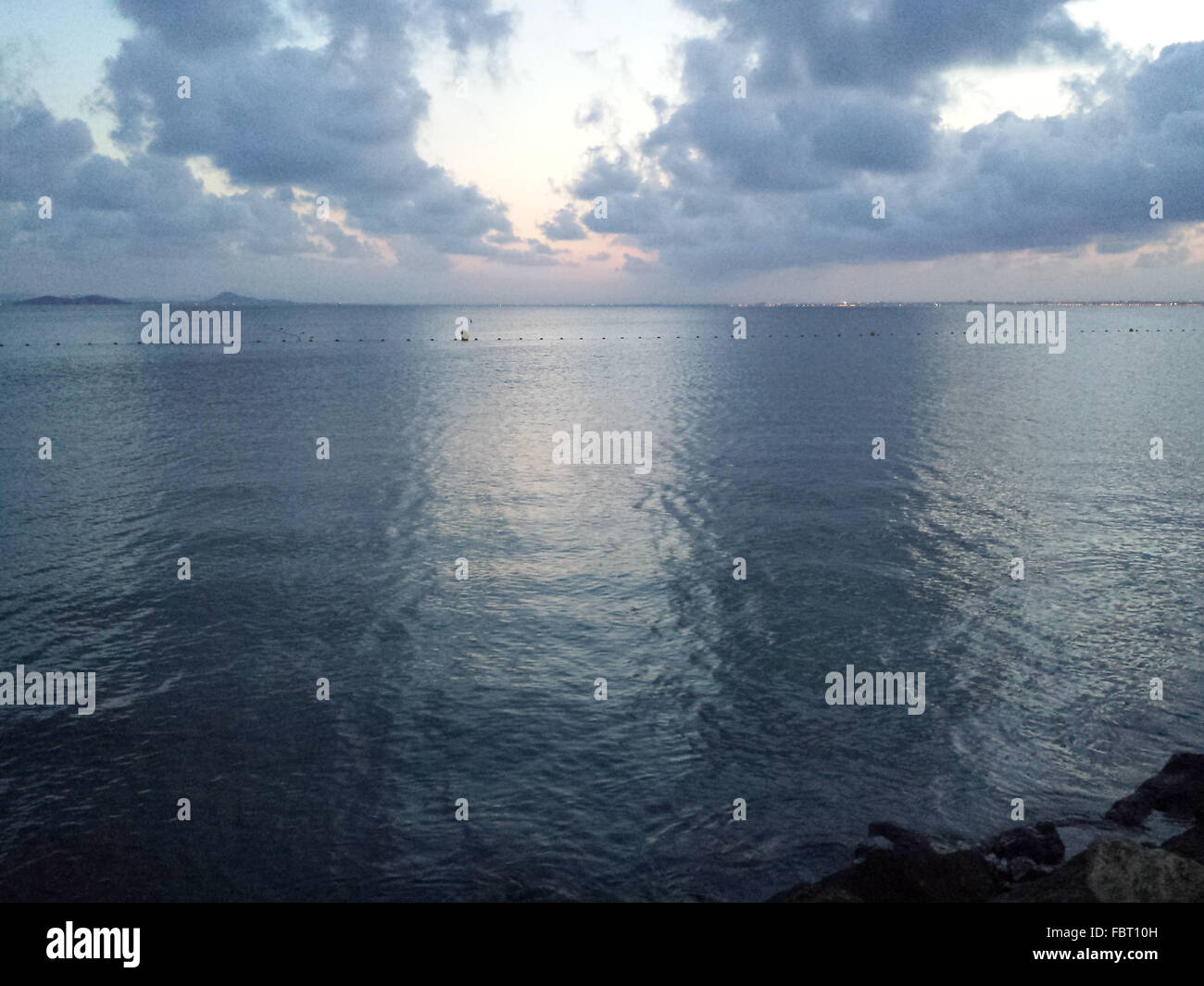 Ruhiges Meer mit Wolken im Wasser gespiegelt Stockfoto