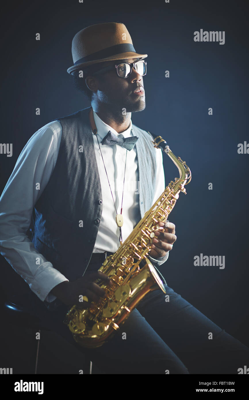 Elegante Jazzer in intelligente Kleidung und Hut mit Saxophon Stockfoto