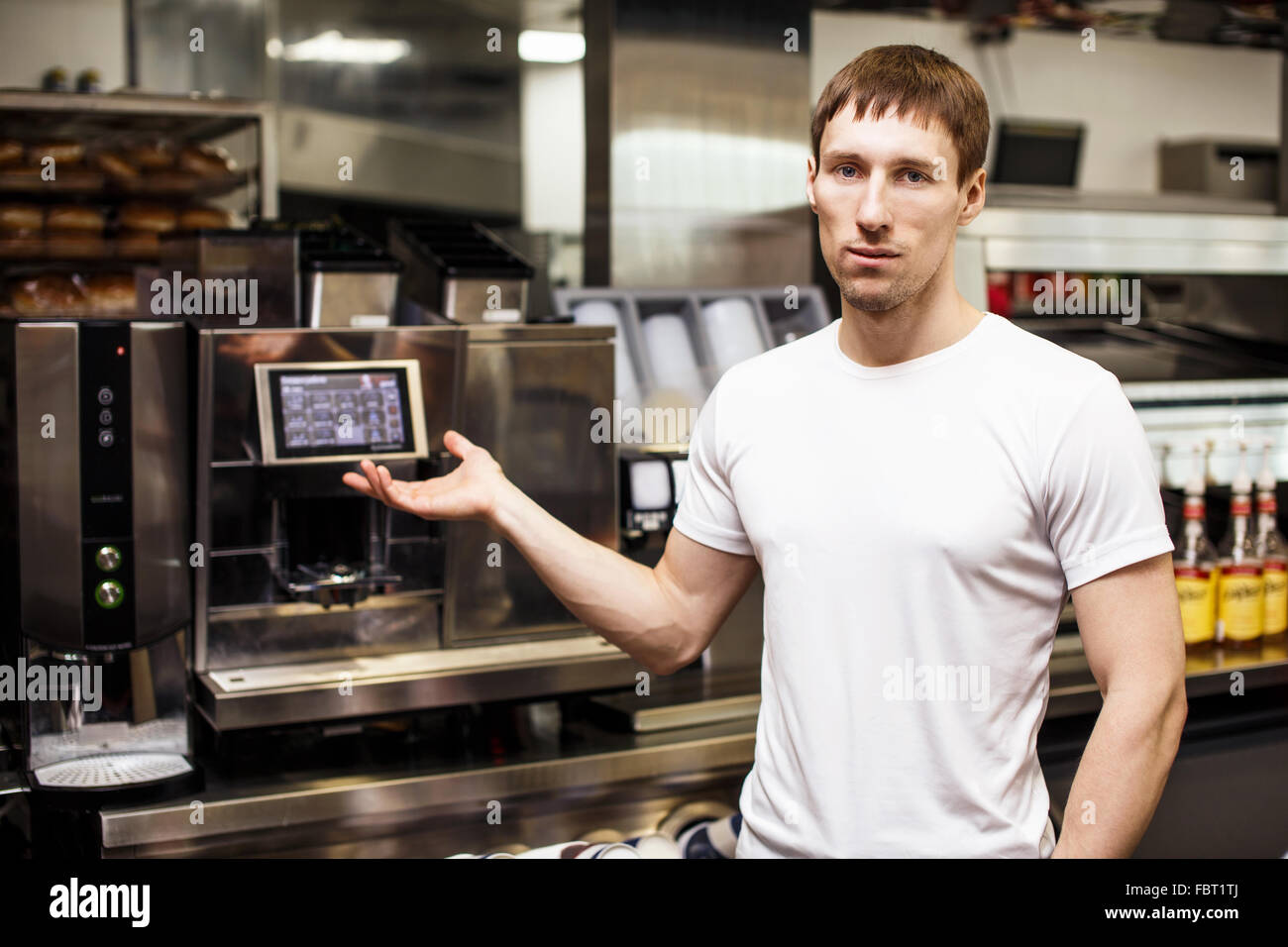 Jungen Barista zeigen professionelle Kaffeemaschine Stockfoto