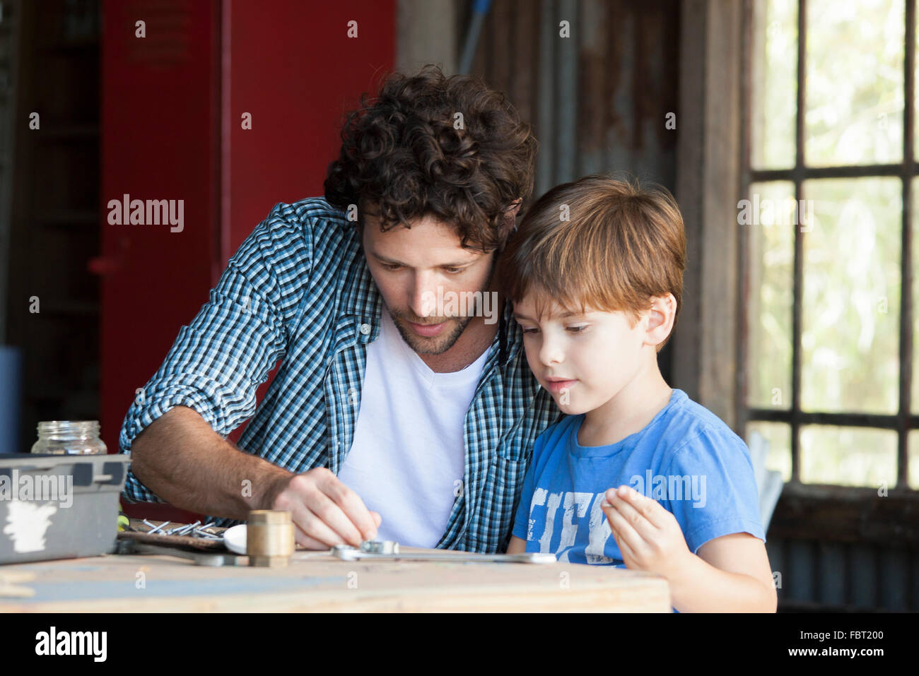 Kind hilft seinem Vater im workshop Stockfoto