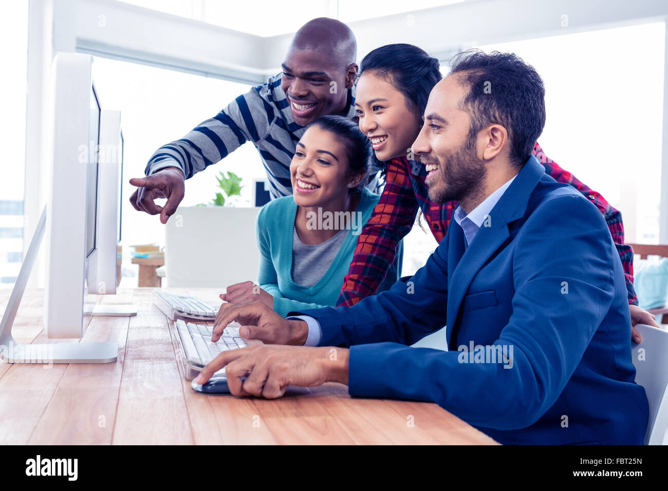 Fröhliche Geschäftsleute, die am Computer-Bildschirm Stockfoto
