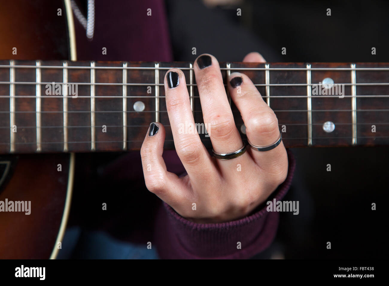 Ein Mädchen Hand einen Akkord auf der Gitarre machen Stockfoto