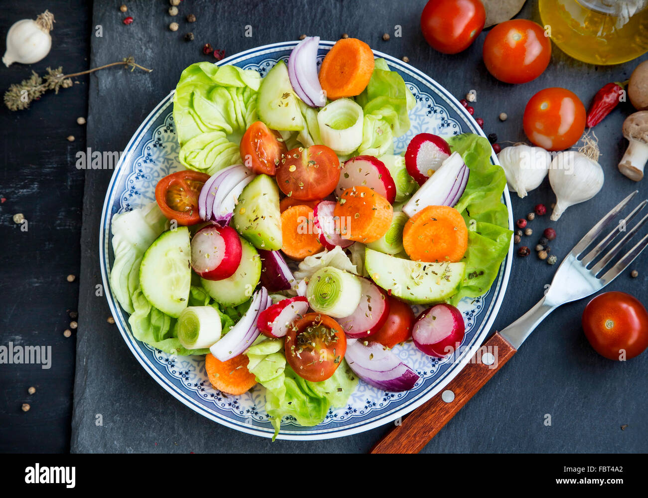 Frisches Gemüse-Salat mit Radieschen, Gurken, Tomaten, Salat, Karotten, Zwiebeln und Gewürzen mischen Stockfoto