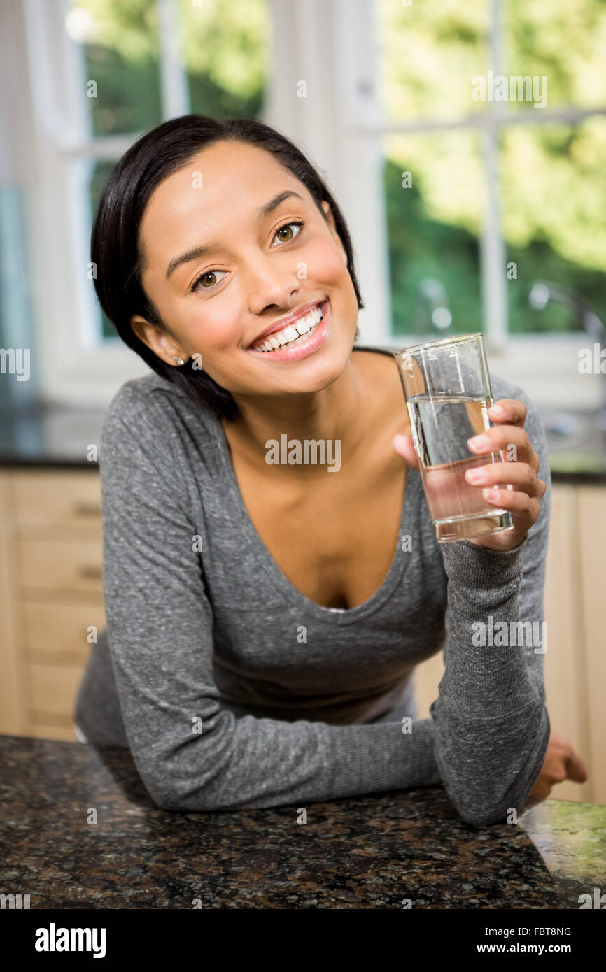 Lächelnde Brünette mit Glas Wasser Stockfoto