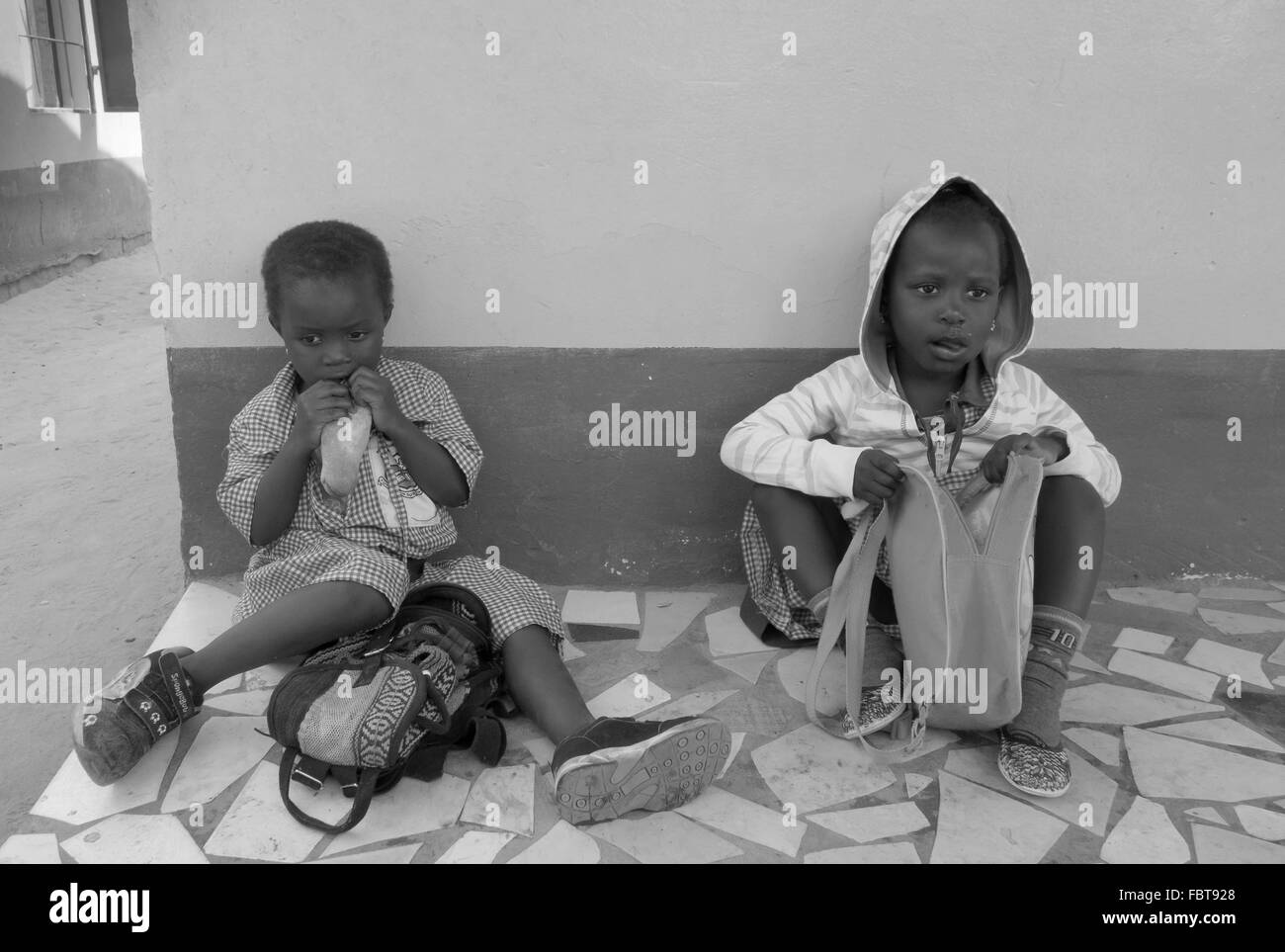 Mittagspause für zwei schwarzen Kleinkind Mädchen an einem Sponsorenlauf Schule in den Seitenstraßen von Kololi Gambia Stockfoto