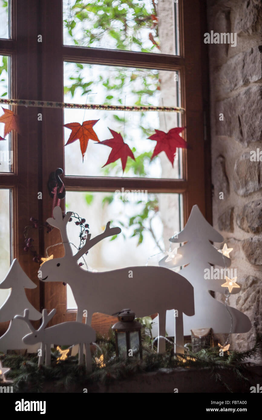 Fensterbank mit Festliche Weihnachtsdekoration, einschließlich Rentiere, Märchenlichtern und Tanne Äste Stockfoto