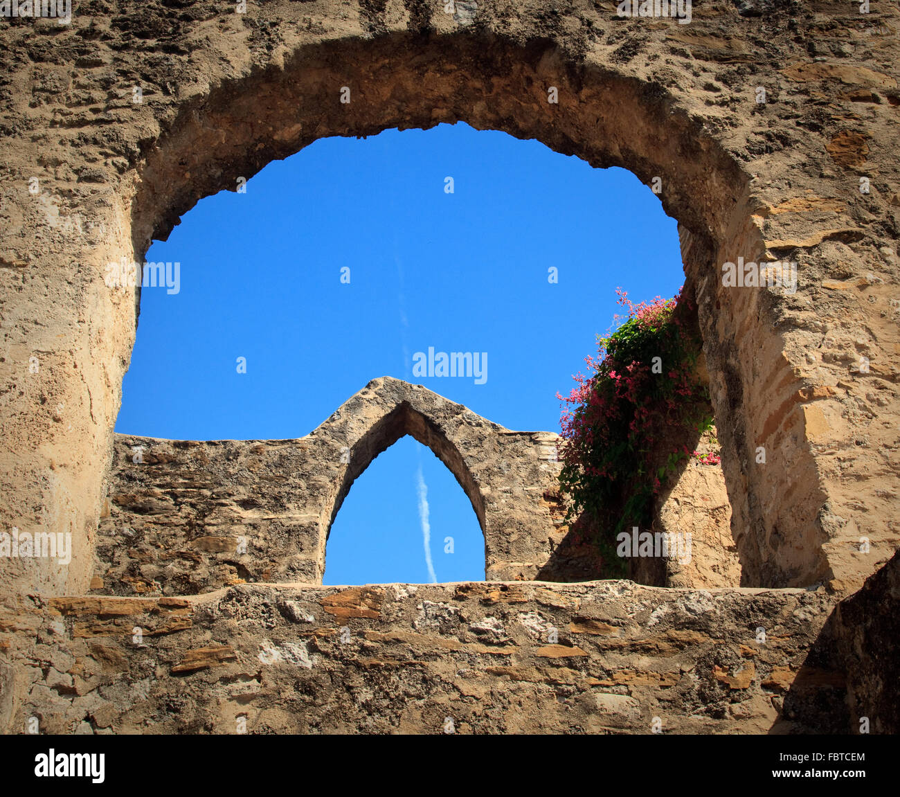 Blick auf einen alten Bogen in Mission San Juan in Texas mit modernen Jet Trail in Himmel Stockfoto