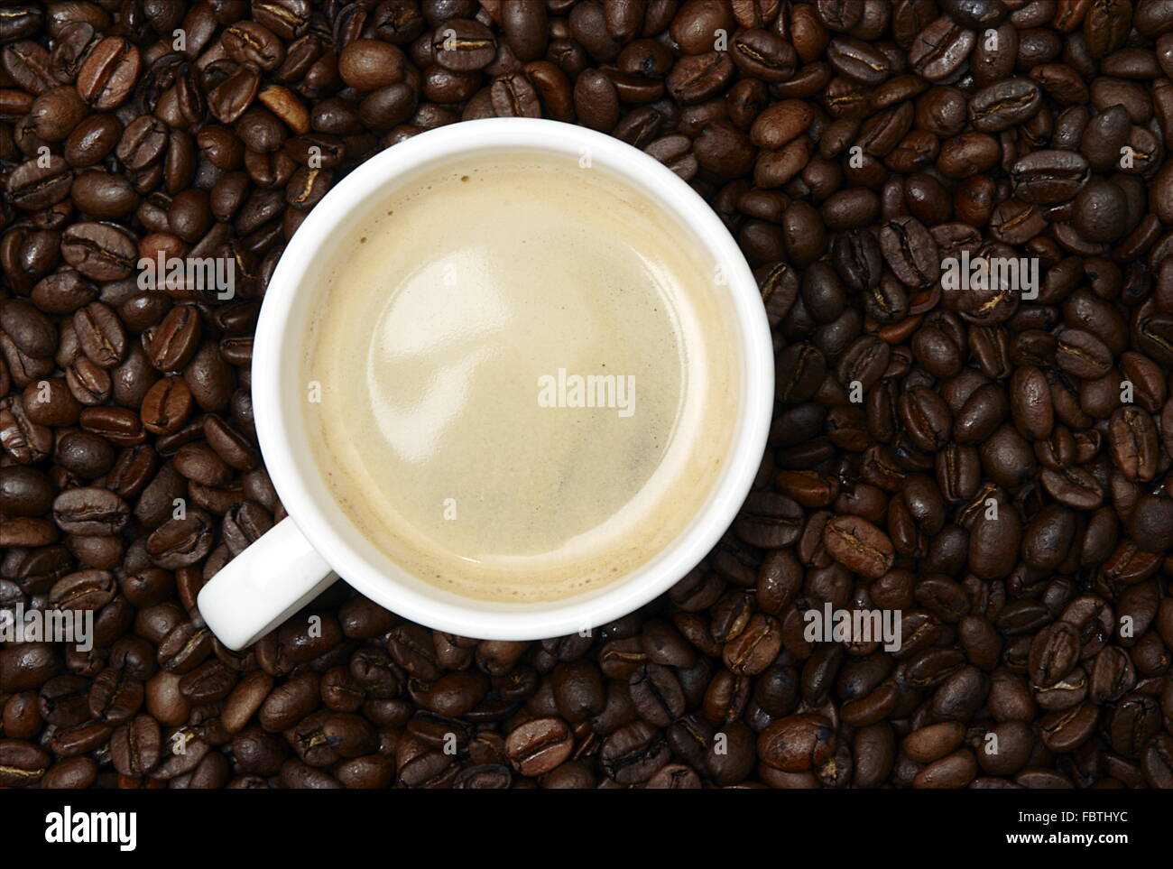 Kaffeetasse in Kaffeebohnen Stockfoto