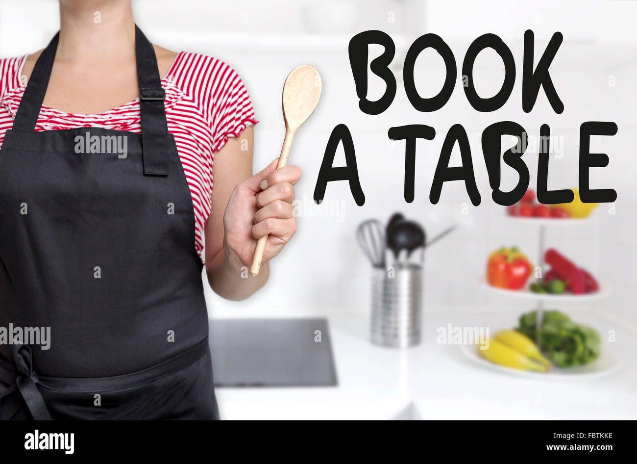 Buchen Sie einen Tabelle Koch holding Holzlöffel Konzept. Stockfoto