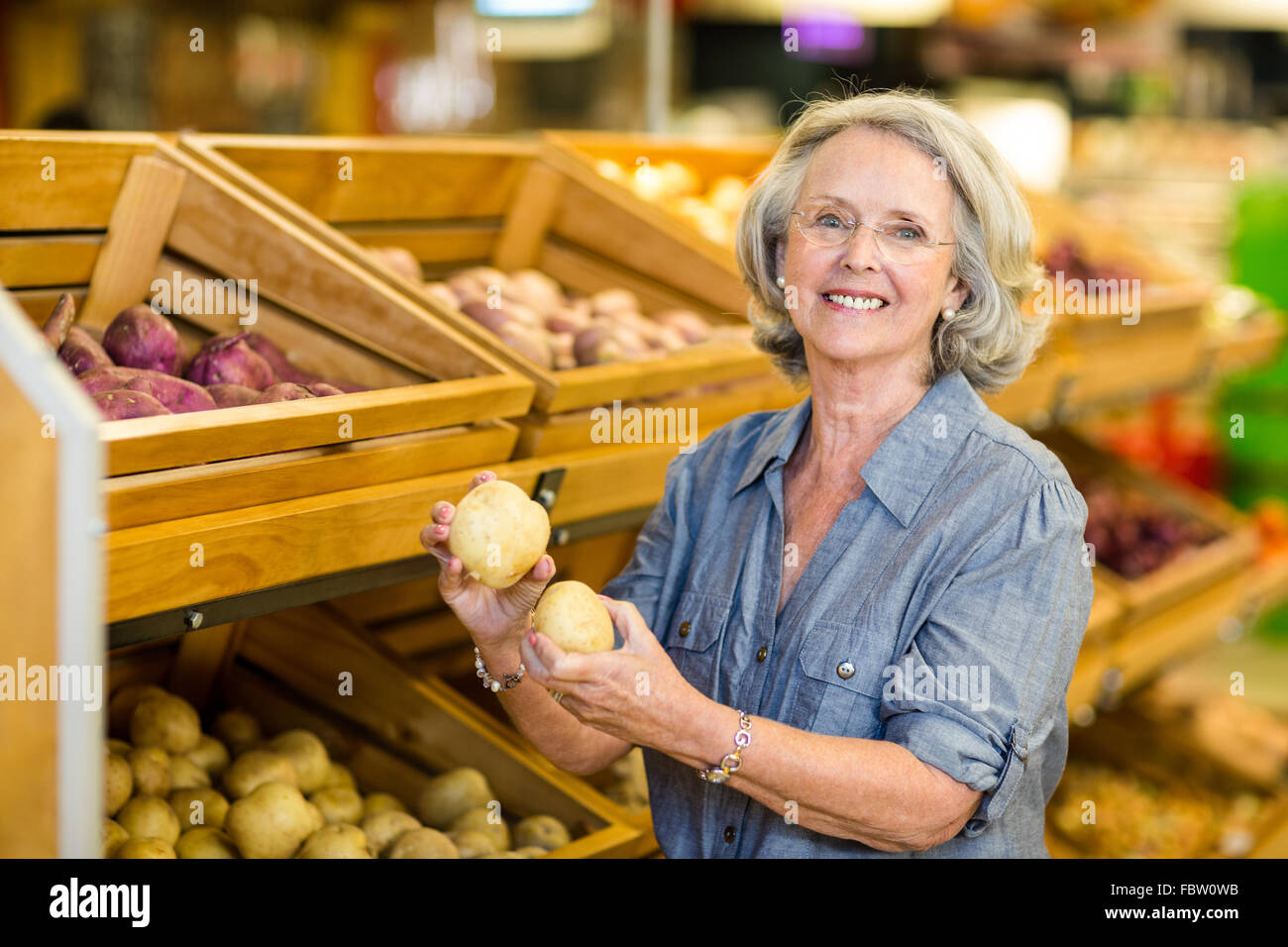 Lächelnde ältere Frau mit Kartoffeln Stockfoto