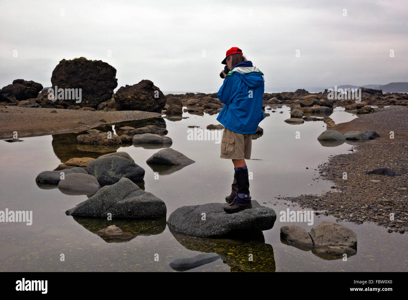 BRITISH COLUMBIA - Wanderer, die Reflexionen der Felsen in Krippen Creek entlang der West Coast Trail in der Pacific-Rim-Park zu fotografieren. Stockfoto