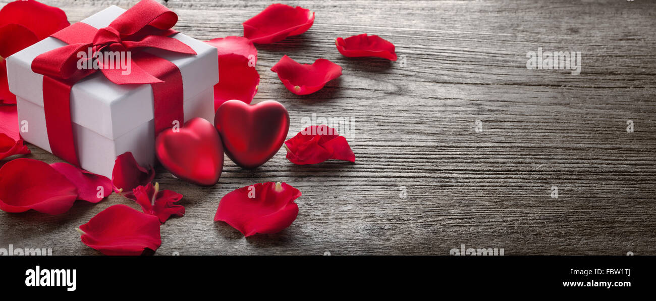 Geschenk-Box und Strauß roter Rosen auf rustikalen Holz, Valentine Hintergrund. Stockfoto