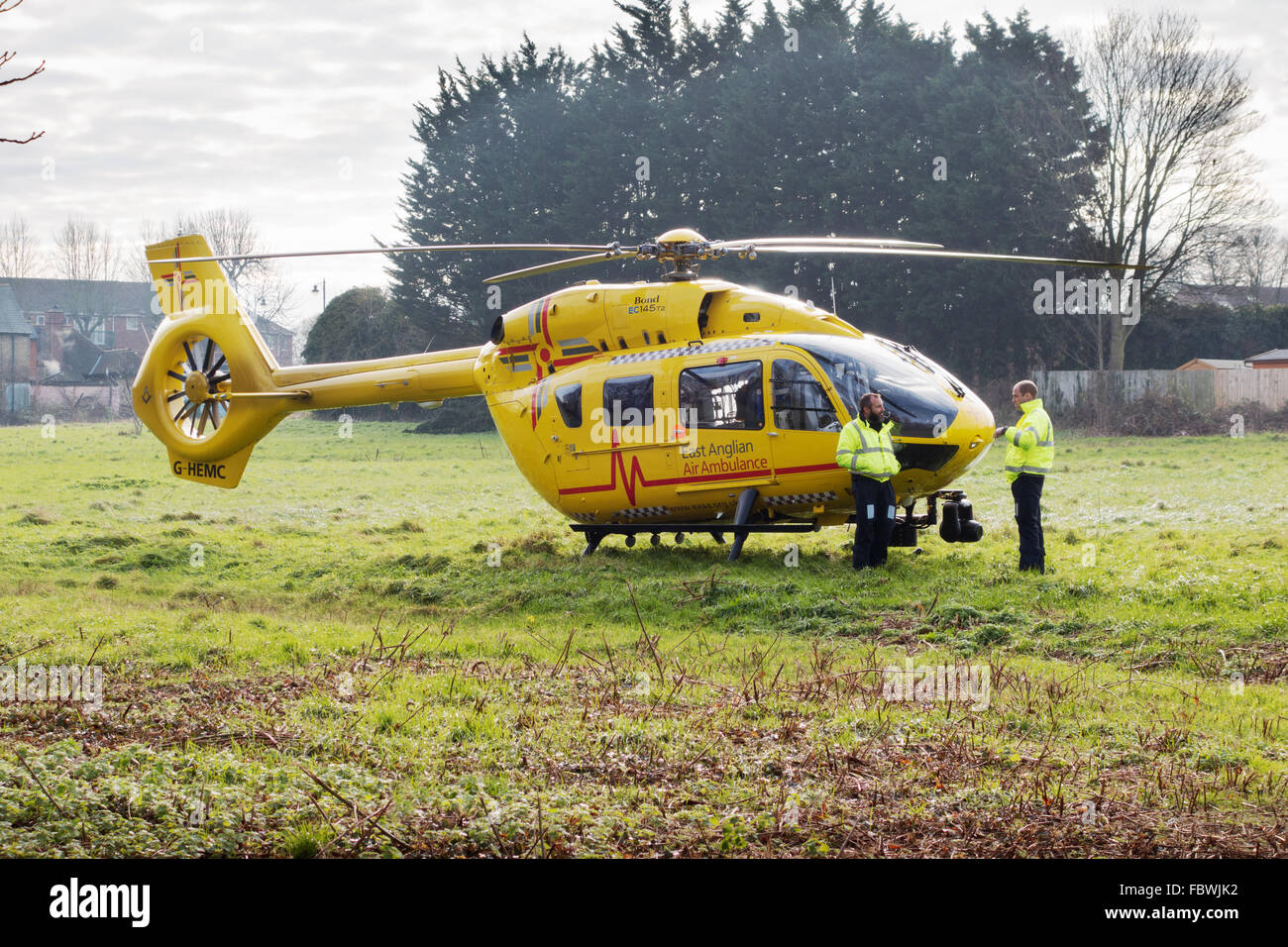 Prinz William, (stehend rechts) Piloten East Anglian Air Ambulance auf ein Feld in Newmarket ermächtigt einen Unfall, Suffolk UK Stockfoto