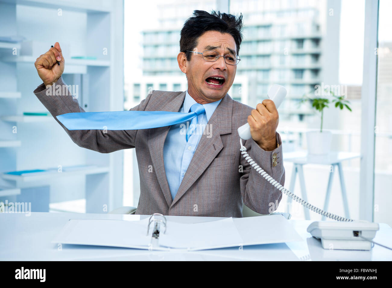 Geschäftsmann, schreien, als er hält, Telefon Stockfoto