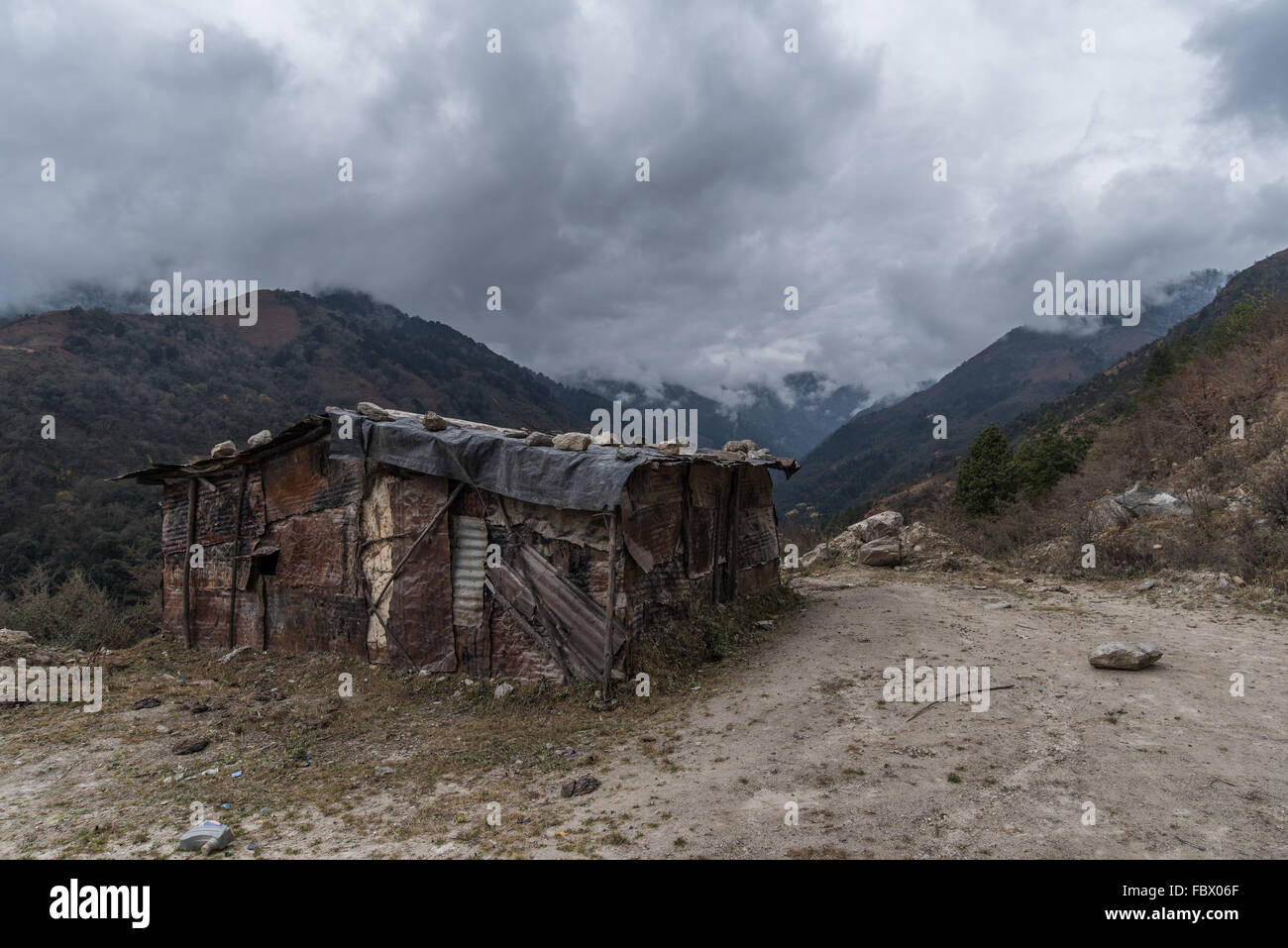Schöne verlassene, rustikale und abgelegene Hütte. Ein Flickwerk aus Metall und Kunststoff, um es vor den Elementen zu schützen. Sela Pass, Arunachal Pradesh, Indien Stockfoto