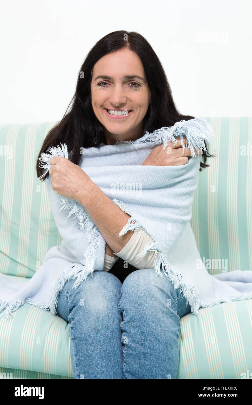 Frau mit einer Decke auf der couch Stockfoto