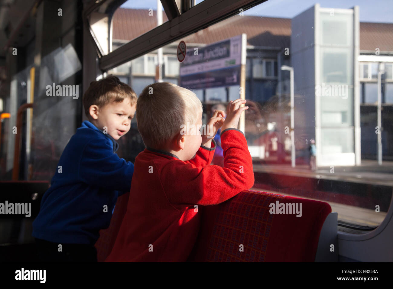 Zwei jungen schaut aus dem Fenster Wagen in Richtung Clapham Junction Bahnsteig während auf einer Zugfahrt, London, UK Stockfoto